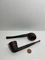 Both rusticated briar pipes side by side with penny for scale