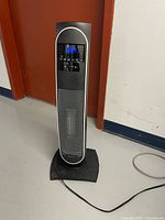 Front view of digital tower heater showing display and grille