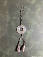 Full view of pendant with jade disc, chain, and bell dangles