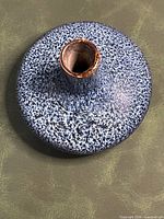 Top view of blue and white speckled ceramic bud vase showing flattened body and narrow neck