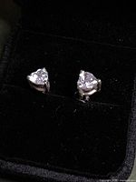 Earrings in box showing trilliant stones and silver setting