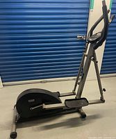 Side view of Universal Fitness 226 elliptical showing compact frame and flywheel housing
