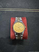 Front view of watch on pillow showing dial, bezel and bracelet