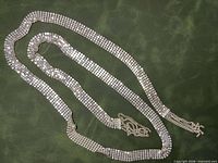 Full view of the metal mesh necklace laid out to show length and overall condition