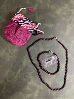 Set overview with pouch, necklace, bracelet in baggie and earrings
