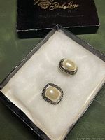 Earrings in silvertone rope frame with cream pearl centers inside Park Lane box
