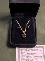 Necklace and earrings set displayed in velvet box, close view