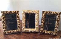 Front view of three gold ornate picture frames