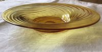 Side profile of amber glass bowl showing shallow depth and spiral ribs