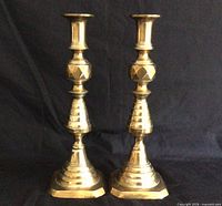 Front view of both brass candlesticks standing upright