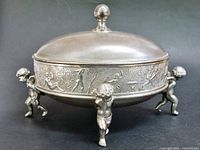 Full view of covered dish showing cherub feet and relief band