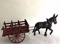 Left side view of cast iron donkey and red cart