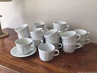 Stacked view of cups and some saucers on wooden surface