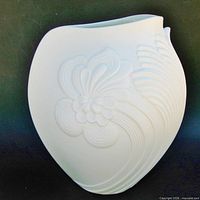 Front view showing embossed floral and leaf relief and asymmetrical rim