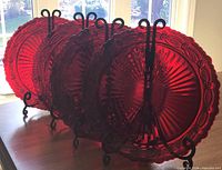 Four ruby red glass dinner plates on stands showing general appearance and quantity