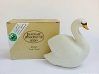 Swan figurine beside branded WWF box