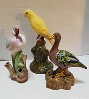 Front view of three ceramic bird flower frogs