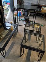 All four glass-top tables grouped in garage