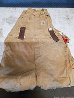 Front view of brown Carhartt insulated bib overalls showing overall condition