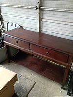 Front view of dark wood console table with two drawers and lower shelf