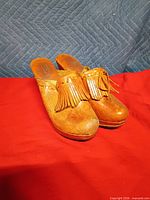 Front view of leather clog heels showing fringe and toe shape