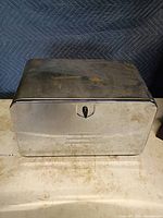 Front view of closed metal bread box