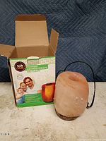 Salt lamp beside open box showing lamp and cord