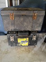 Two stacked toolboxes, showing relative sizes and overall wear