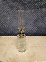 Full view of crystal oil lamp standing upright