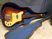 Guitar in open case showing full body, pickup, bridge, controls