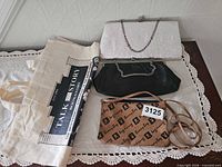 All four bags displayed: canvas tote, silver clutch, black clutch, Bunny Bag crossbody