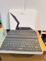 Front view of Apple Magic Keyboard on top of its box, keys and trackpad visible