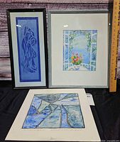 Three artworks arranged: blue figurative, floral doorway, abstract geometric
