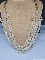 Full view of five-strand faux pearl necklace displayed on bust