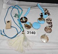All jewelry pieces laid out showing both necklaces and three pairs of earrings with lot tag