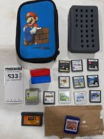 All items laid out: Mario carry case, grey cartridge holder, dust covers, loose cartridges