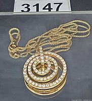Full view of pendant and chain displaying triple circle design and crystals