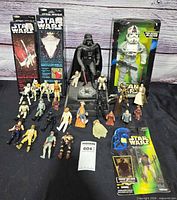 Full group shot showing Darth Vader bank, boxed AT-AT Driver, carded items and loose figures