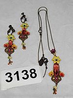 Full view of necklace and both earrings displayed flat