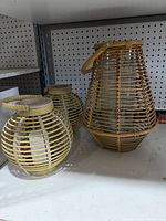 Three rattan lanterns on shelf