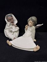 Both figurines side by side on black background