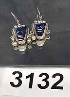 Front view of both earrings showing mask design and missing dangle