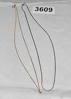 Both chains laid out full length beside lot number for scale