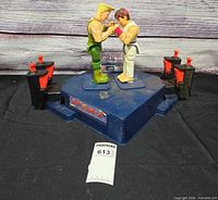 Full view of game base with both fighter figures and four control buttons