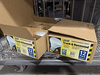 Two open Feit Electric maintenance boxes on shelf