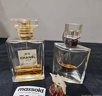 Front view of Chanel and Lancome bottles with mini Nina Ricci in foreground