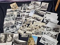 Spread of assorted black-and-white postcards and small prints