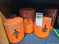 Front view showing four orange West Bend canisters with labels Tea, Sugar, Flour, Coffee