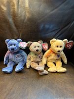 Group shot of Periwinkle, Speckles and Sunny eBears sitting upright with swing tags visible