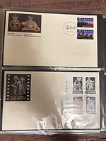 Two first day covers stored in album sleeve, military cover above, performing arts cover below